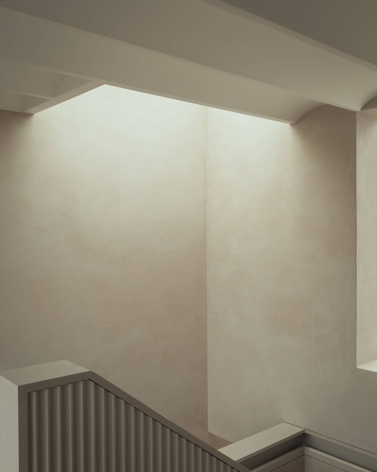 High-angle view of a vaulted plaster stairwell illuminated by hidden architectural skylight cutouts, ideal for creative photography backdrops, Love Locations SO20.