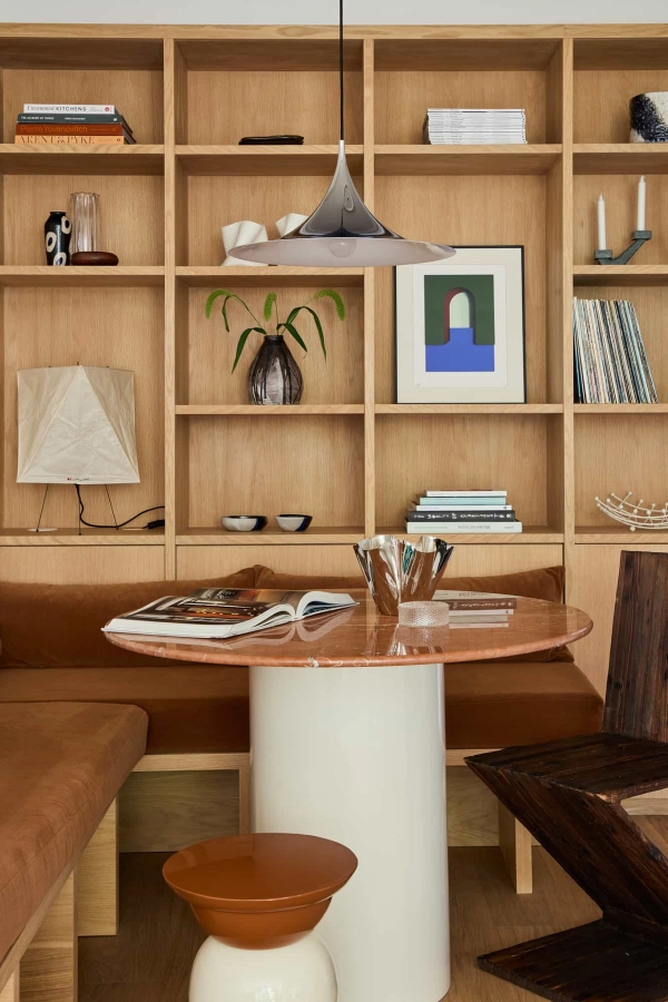 Love Locations scandi style dining room Lewisham SE23: Detailed look at an integrated wooden bench dining booth under custom open bookshelves, optimized for home decor brand staging.