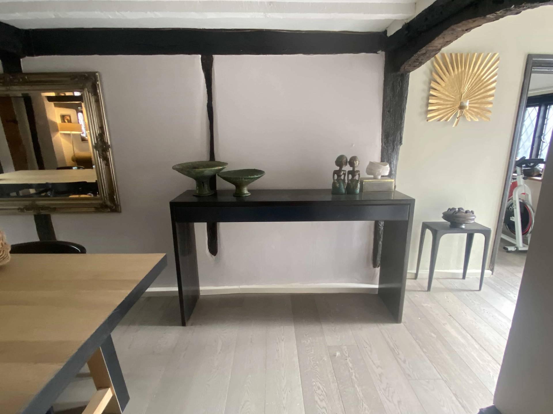 Minimalist hallway display table against white walls and dark historic timber framing, perfect for homeware brand campaigns, Love Locations.