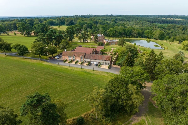 Aerial view of the modern barn event complex surrounded by formal gardens and rural woodland, listed on Love Locations.