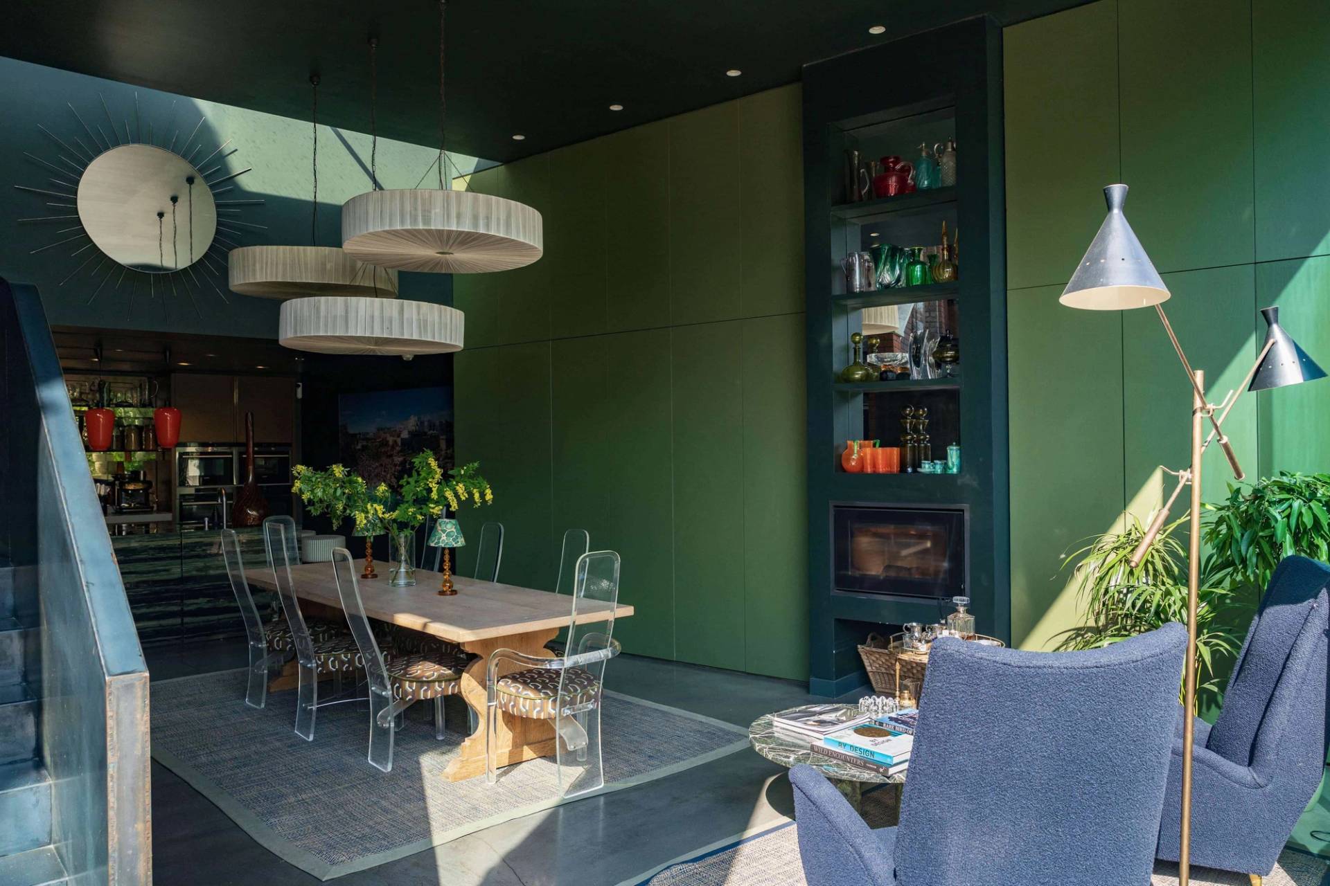 Lounge nook in a modern architectural extension featuring a blue armchair, fluted fireplace, and high olive green walls, ideal for domestic brand ads, Love Locations.