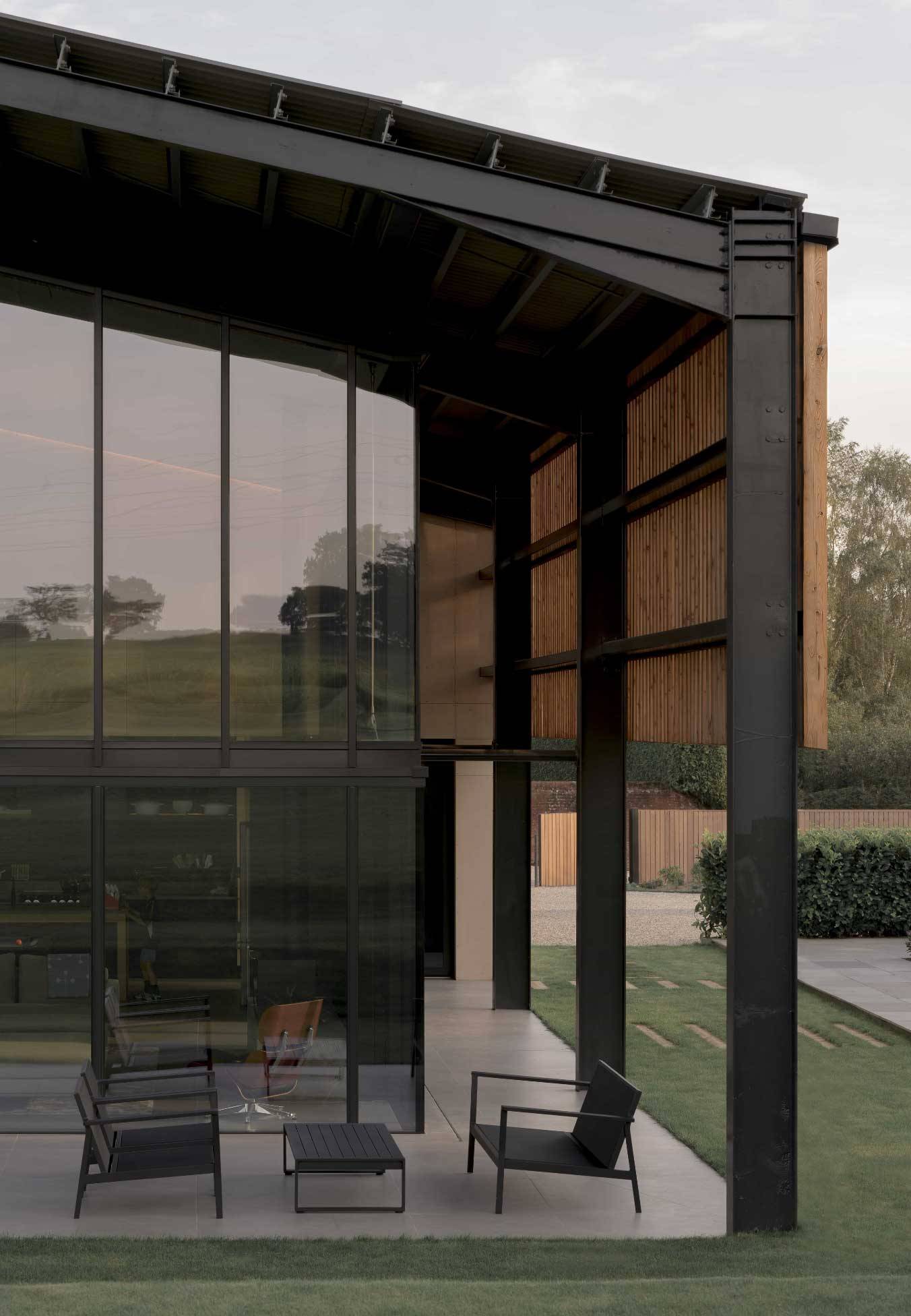Architectural exterior detail showcasing floor-to-ceiling glass curtain walls and dark steel structural beams, Love Locations NR9.
