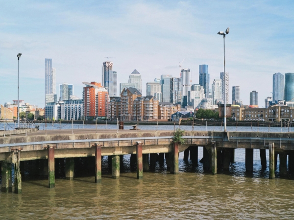 Authentic industrial timber jetty pier on the River Thames with a panoramic city skyline backdrop, unique London film location via Love Locations.