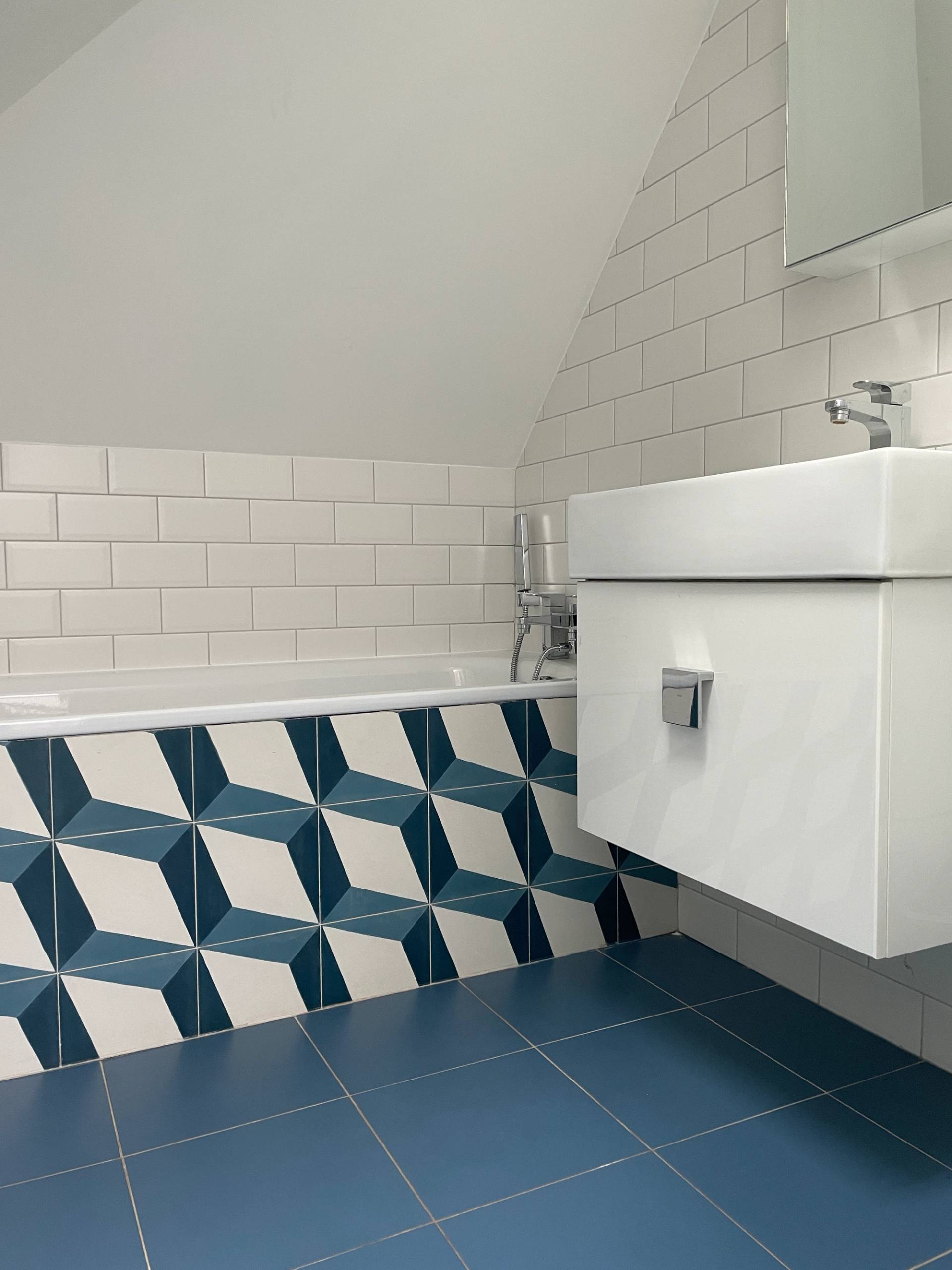Attic bathroom suite with blue geometric 3D cube wall tiles, white vanity sink, and white subway tiling, Love Locations Ealing Common.