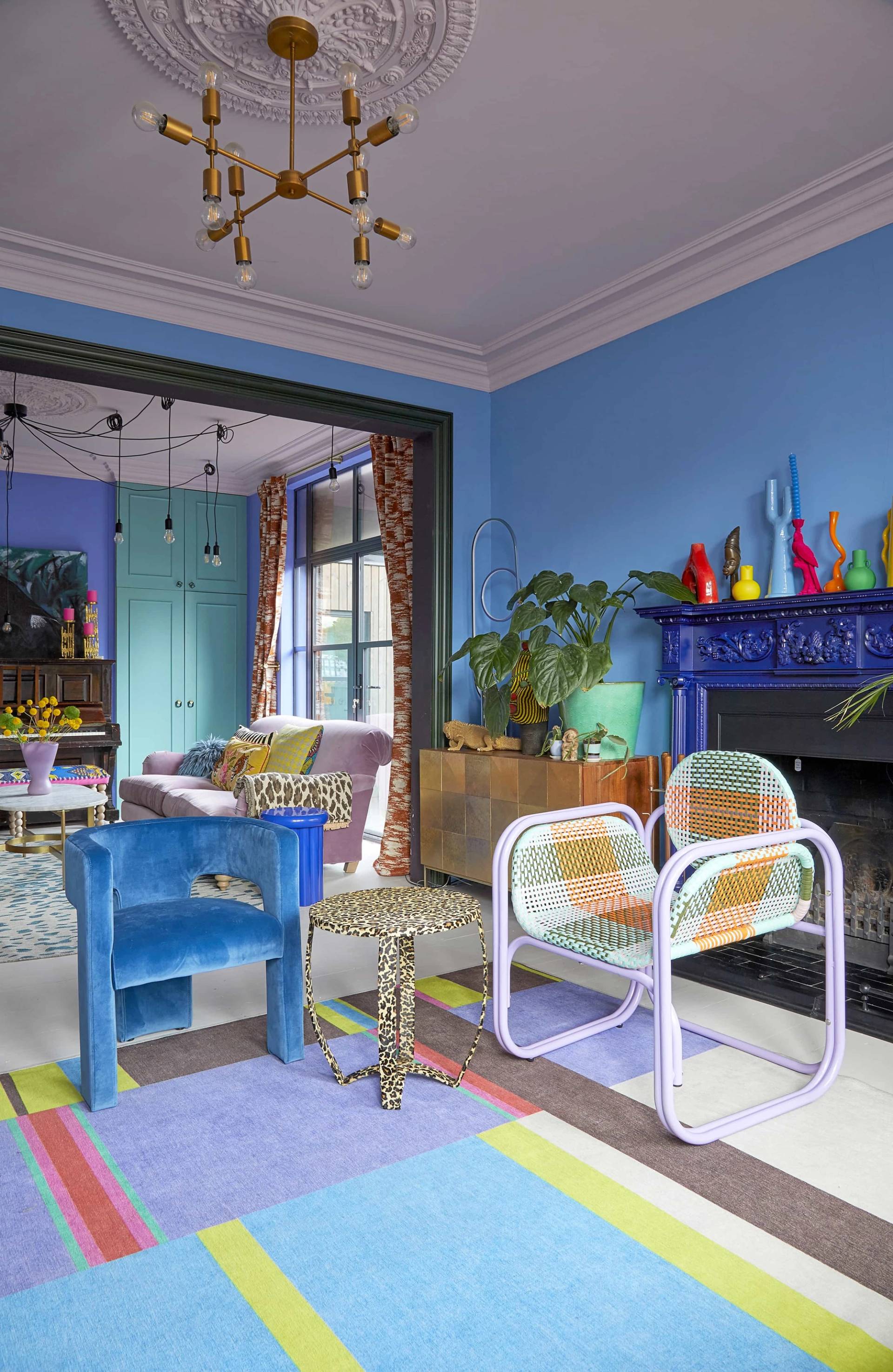 Colorful reception room transition with blue walls, patterned armchairs, and yellow double door frames, Love Locations Catford.