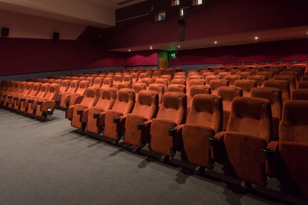 Wide perspective across the empty red velvet seats and dark acoustic walls in The Ritzy Screen 2 cinema auditorium in Brixton SW2 managed by Love Locations.