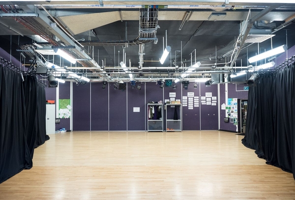 Love Locations school drama studio location BS7: Multi-use activity hall with exposed ceiling fixtures and purple accent wall panels, excellent for music videos and corporate media production.