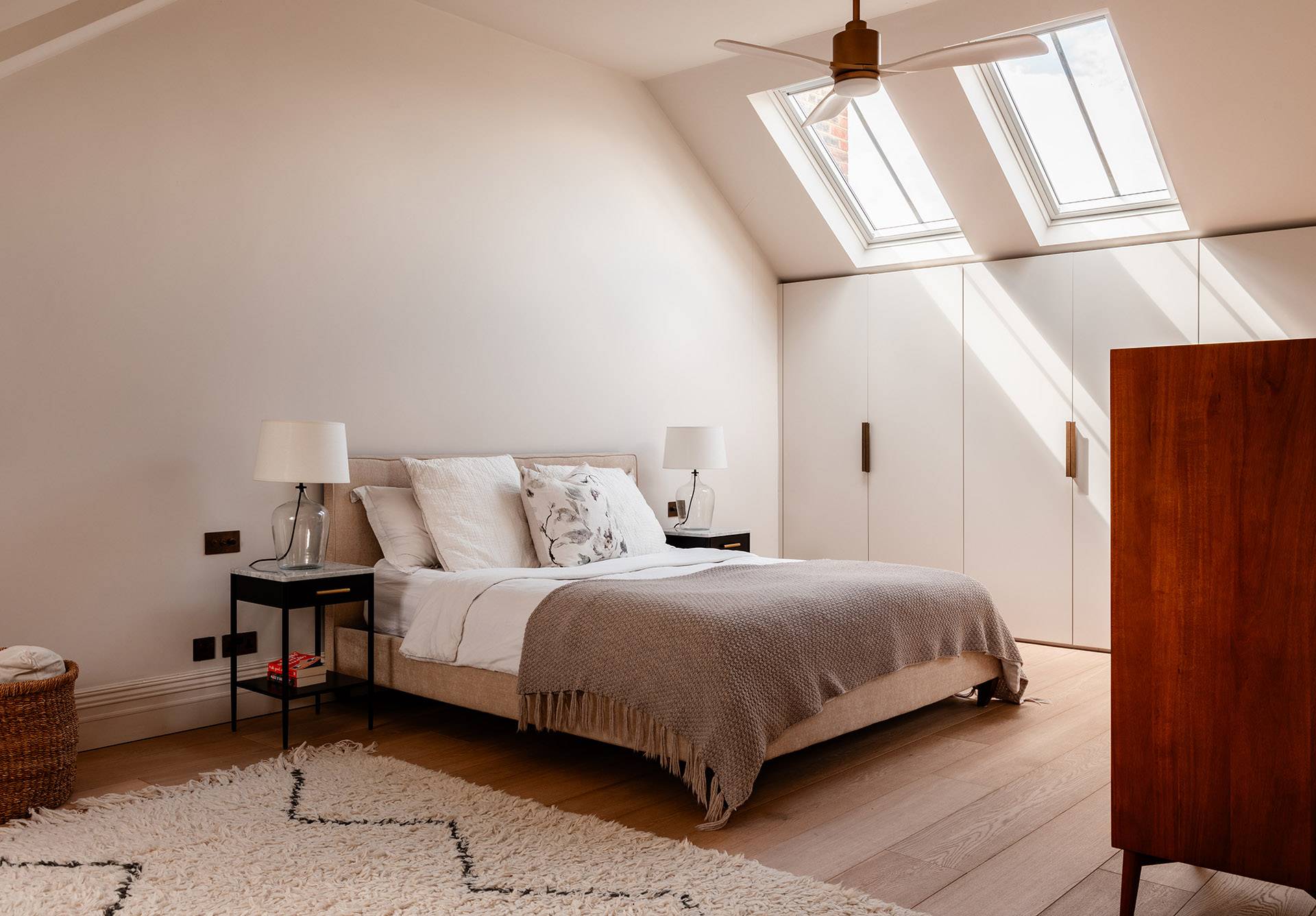 Attic master bedroom shoot location featuring skylight windows, built-in wardrobes, and neutral bed linens, ideal for mattress and bedding lookbooks, Love Locations TW1.