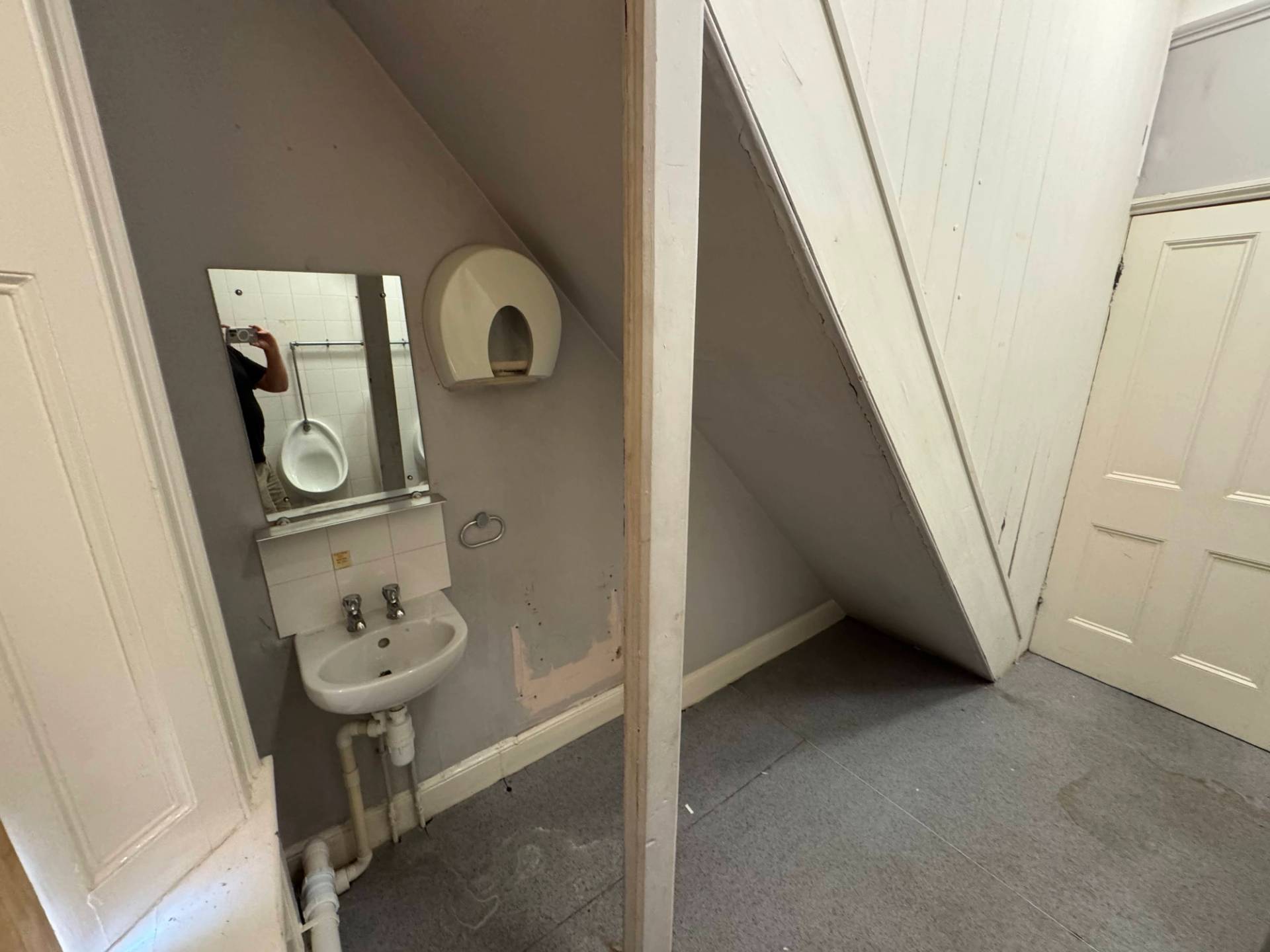 Small compact sink basin installation fitted under a sloped staircase ceiling structure, via Love Locations NG9.