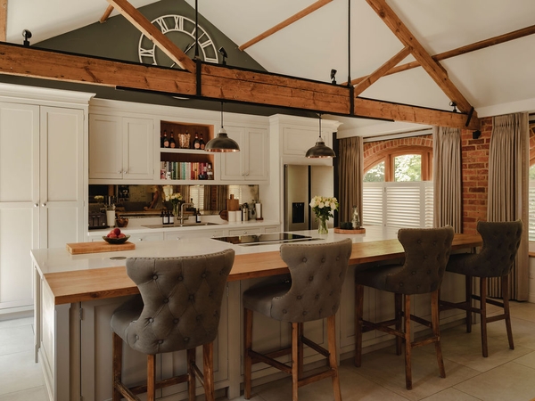 Open-plan barn kitchen and dining zone showcasing dark wood beams and integrated appliances in Nuffield, Henley-on-Thames, ideal for family brand advertising, Love Locations RG9.