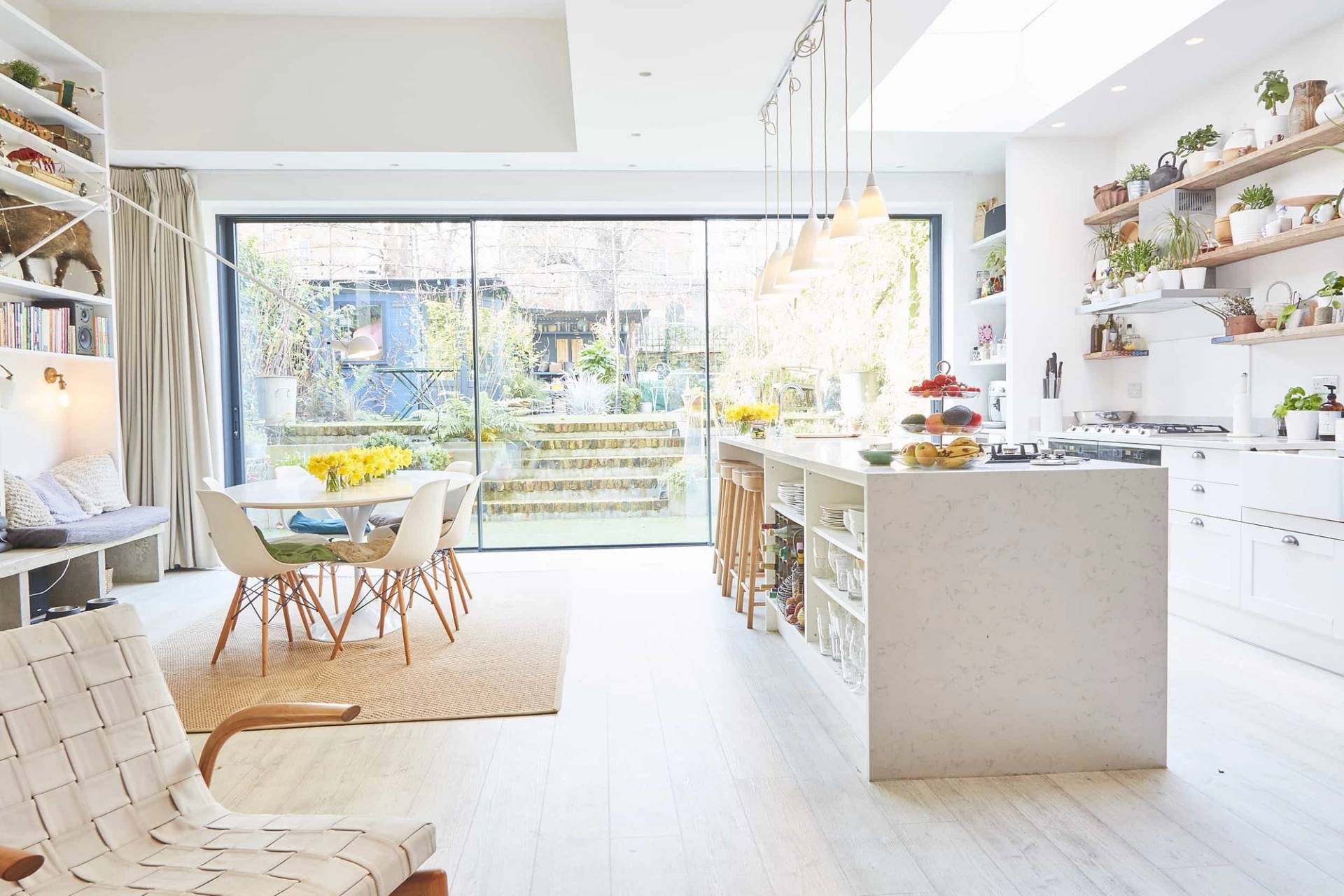Bright open-plan kitchen shoot location in Islington, N5 featuring a large terrazzo island, wooden bar stools, and full-height sliding glass doors via Love Locations.