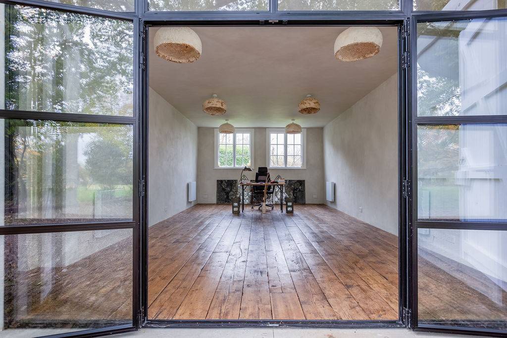 Bright minimalist living space with original wooden floors at Love Locations in Liss, Hampshire GU33.
