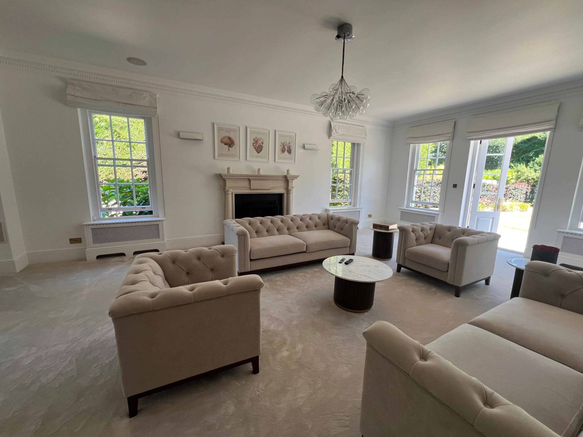 Lounge room view with stone fireplace surround, cream sofas, crystal lighting, and sash window light, Love Locations BR7.