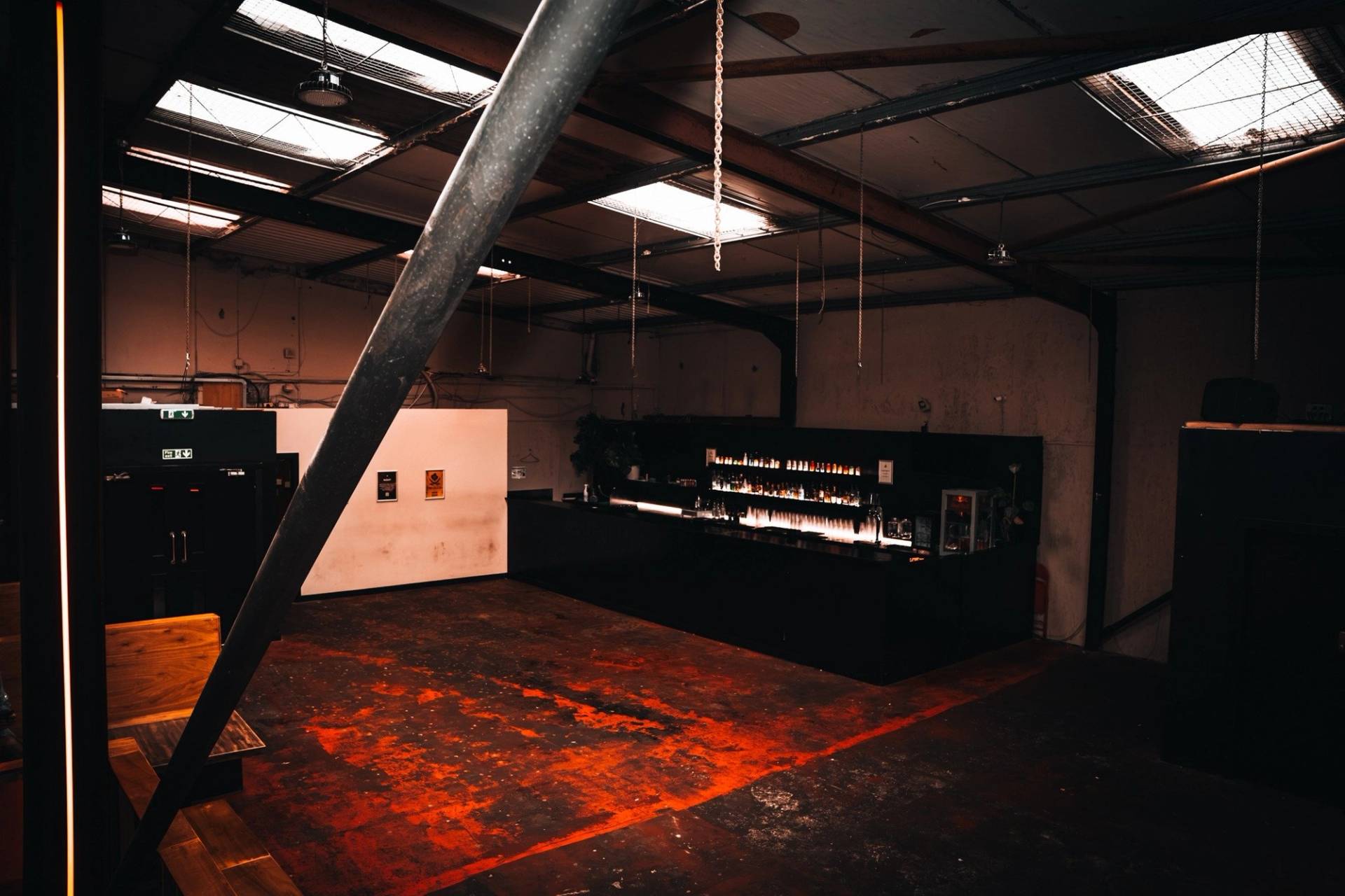 High-ceiling industrial warehouse event space with skylight panels and warm perimeter seating in Cheetham Hill through Love Locations.