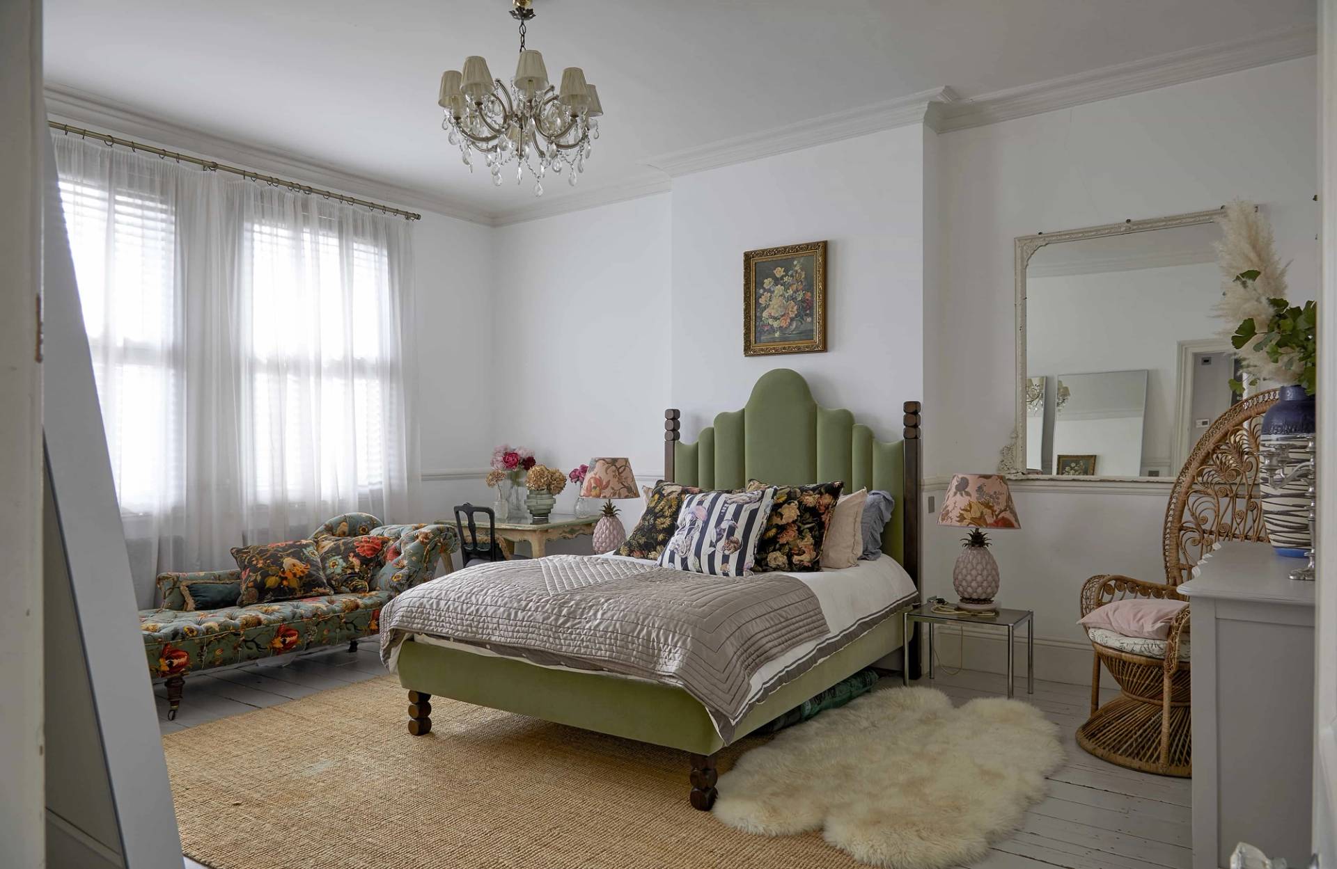 Period bedroom suite featuring a green velvet headboard, ornate white ceiling rose, and sheepskin rug, Love Locations N16.