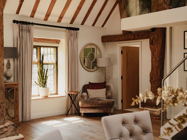 Cozy armchair sitting area illuminated by natural light through multi-pane windows in a Nuffield location house, Love Locations.