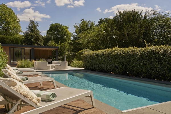 High-end residential swimming pool area surrounded by manicured privacy hedges, available through Love Locations.