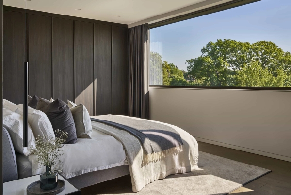 Luxury minimalist bedroom shoot location with a large picture window showcasing treetop views, curated by Love Locations.