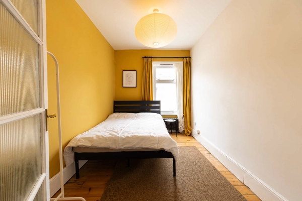 Love Locations bright residential location Forest Gate East London: Golden-toned bedroom layout showcasing rich pine floors and natural light, tailored for interior design lookbooks and video shoots.