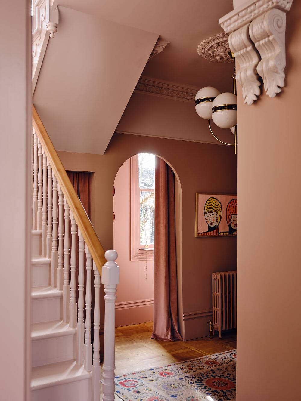 Grand plaster pink hallway with an arched doorway, period staircase, and heavy drapes, Love Locations CR0.