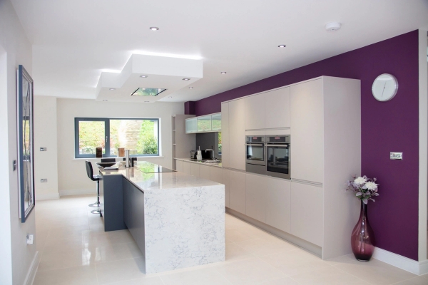 Luxury modern open-plan kitchen shoot location with a marble waterfall island and sleek white cabinets in Guildford, Surrey, GU5, ideal for celebrity cooking shows via Love Locations.