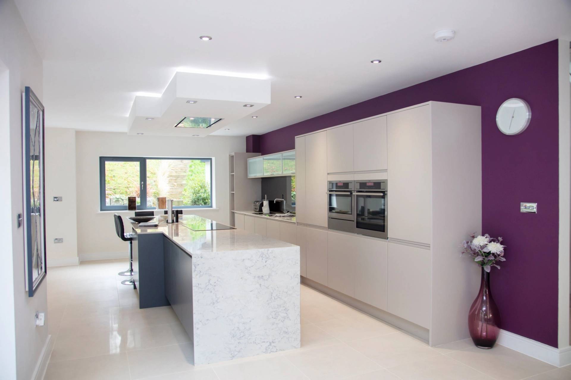 Luxury modern open-plan kitchen shoot location with a marble waterfall island and sleek white cabinets in Guildford, Surrey, GU5, ideal for celebrity cooking shows via Love Locations.