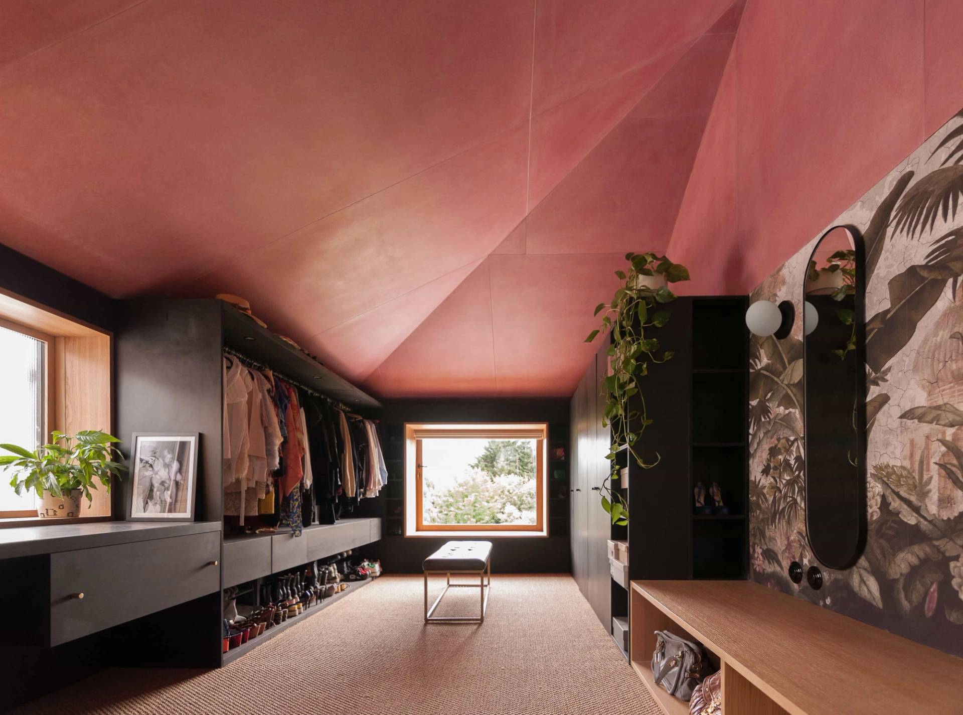 Atmospheric walk-in closet dressing room shoot location in Hackney London N16 through Love Locations, featuring deep terracotta rose walls and open dark wood shelving.