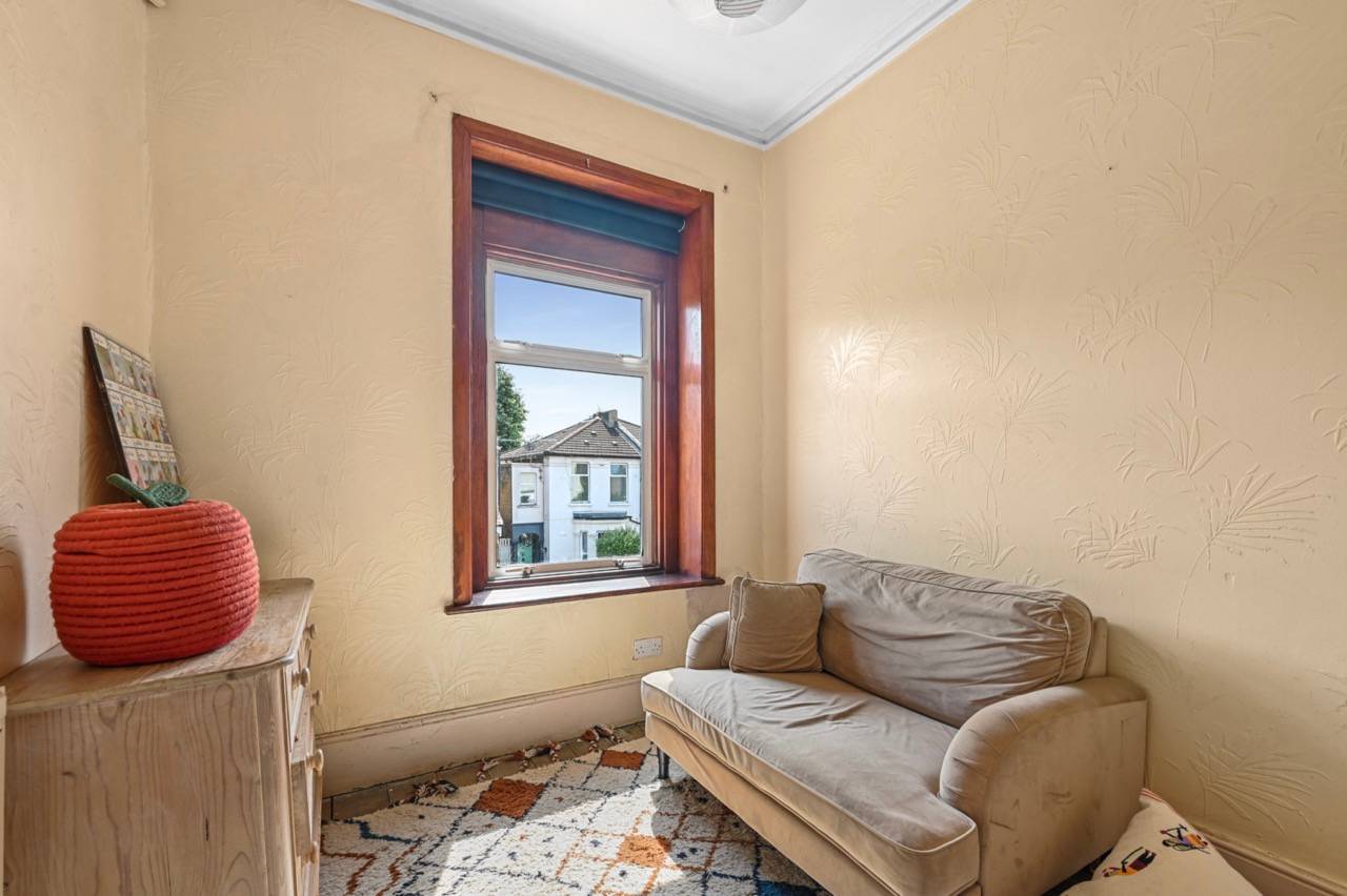 Cozy sitting nook with warm yellow plaster walls, small sofa, and sash window light, Love Locations E7.