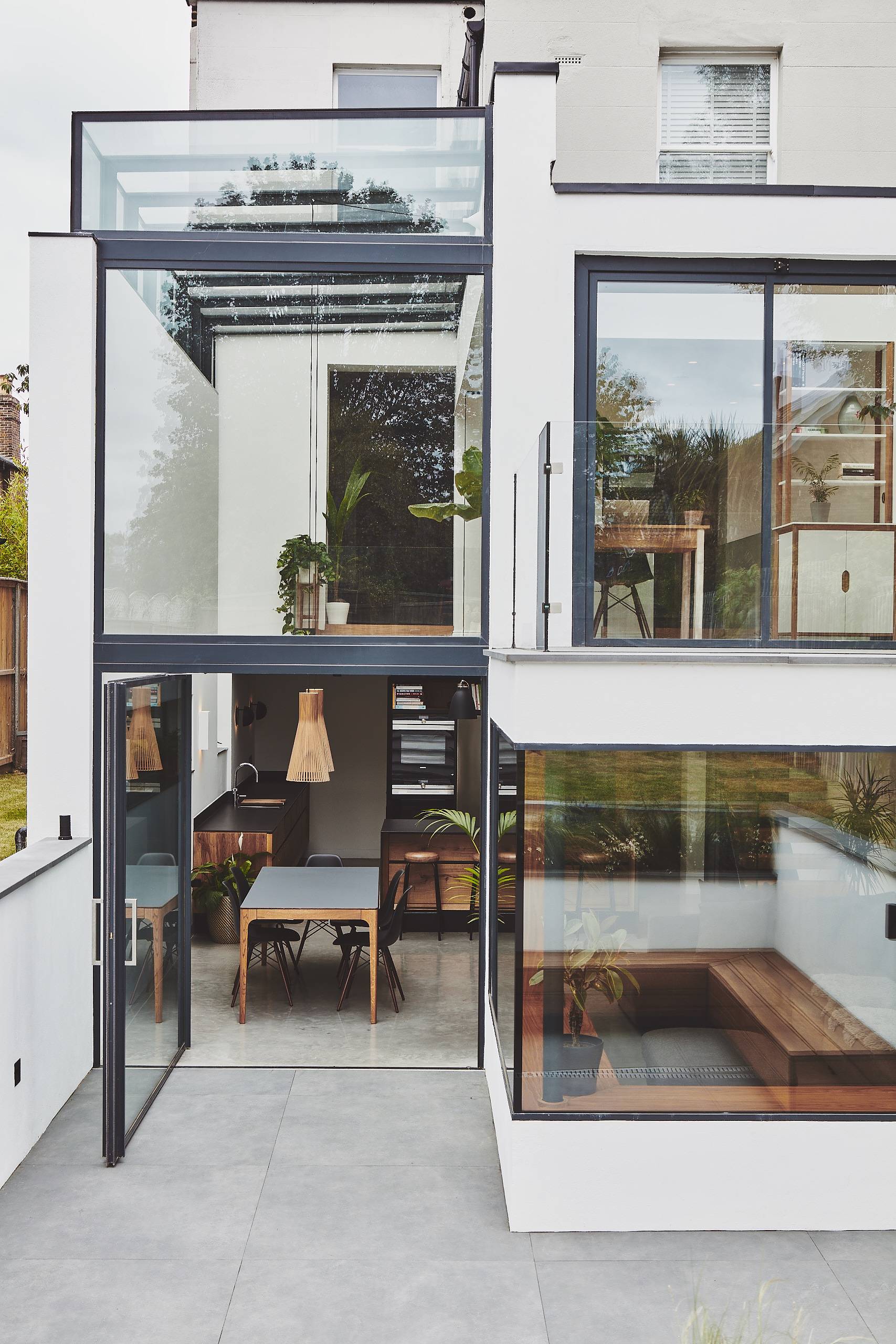 Exterior architectural view of a multi-level glass extension and sunken courtyard patio in Twickenham, Love Locations TW1.