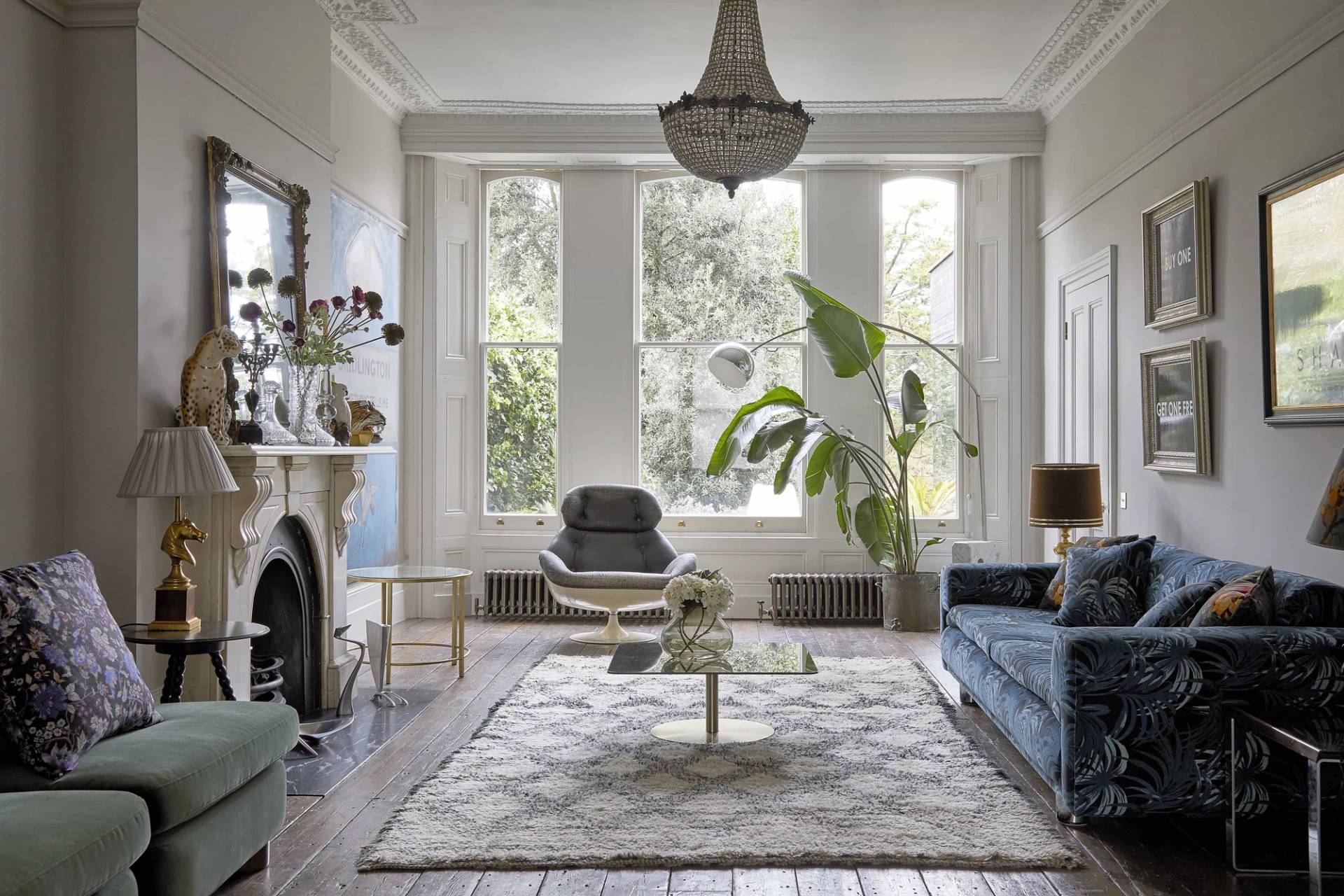 Bright second reception room with large bay windows, blue patterned sofa, geometric area rug, and grand marble fireplace, Love Locations N16.