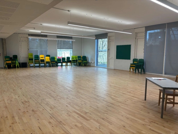 Large empty school hall with bright wooden floors and large windows, ideal for dance rehearsals or filming via Love Locations.