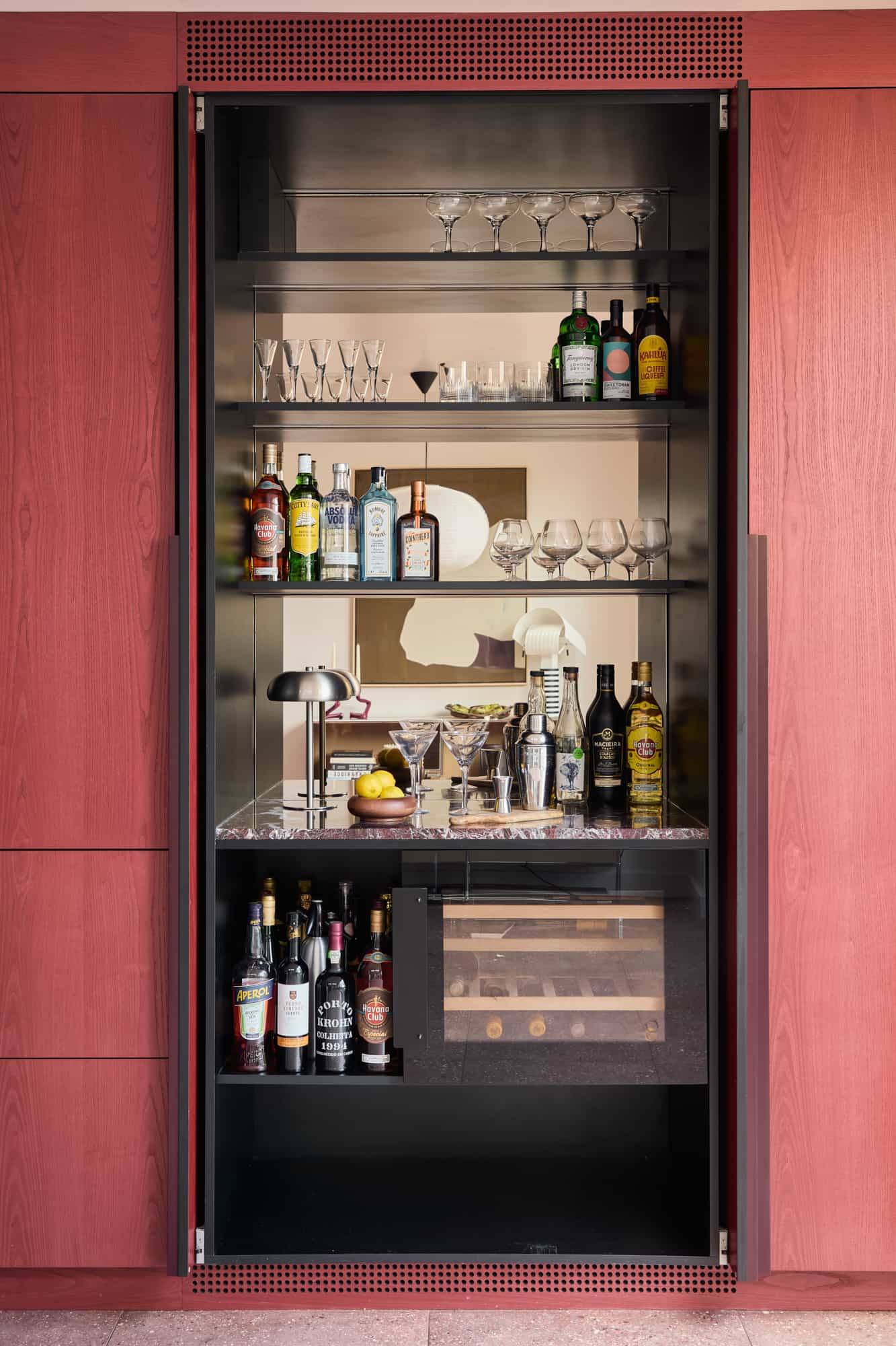 Love Locations executive residential location Lewisham: Close-up of a bespoke hidden bar unit featuring an integrated wine fridge and glass racks, designed for premium alcohol advertising.