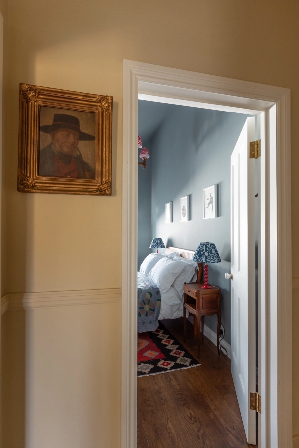 Peeking view into a bright bedroom from a moody, yellow-walled corridor, a versatile production location in Westminster SW1V by Love Locations.