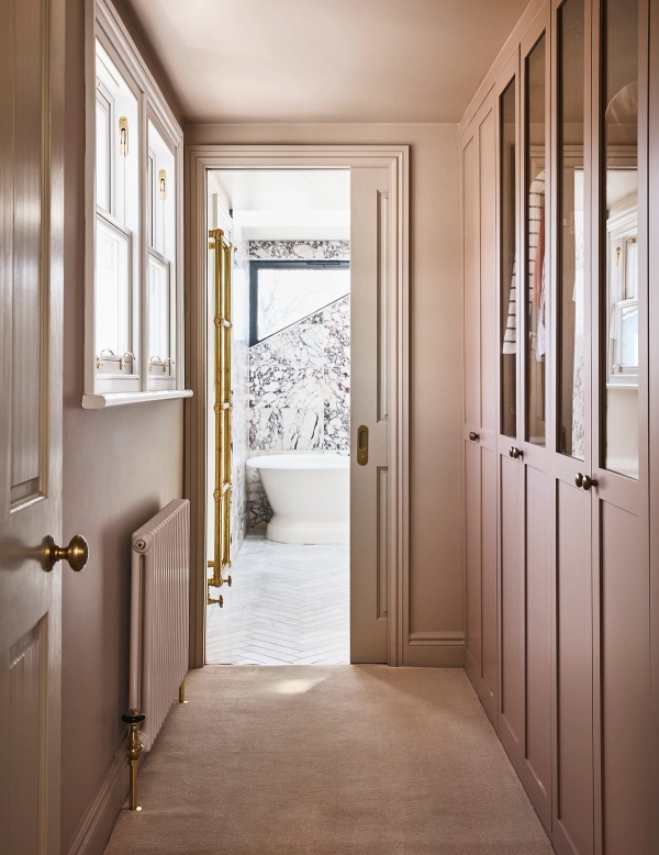 Dressing room hallway view looking through an open door into a marble master bathroom suite, Love Locations SE21.