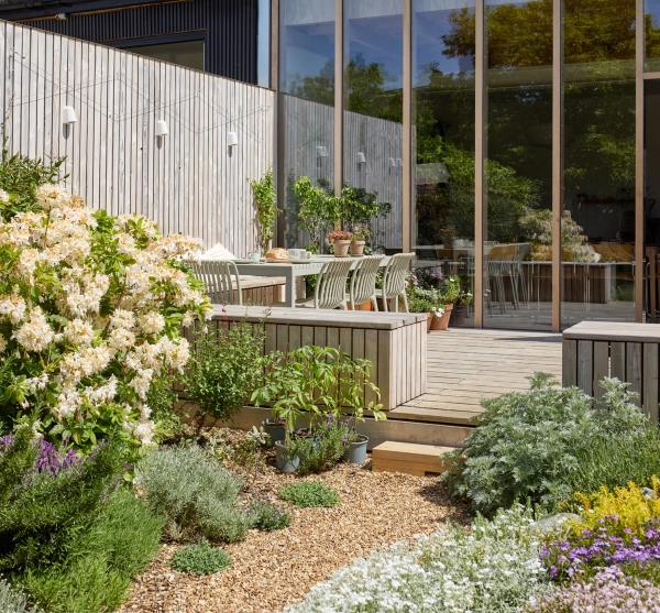 Timber deck patio terrace set with outdoor seating beside gravel garden borders, Love Locations E17.