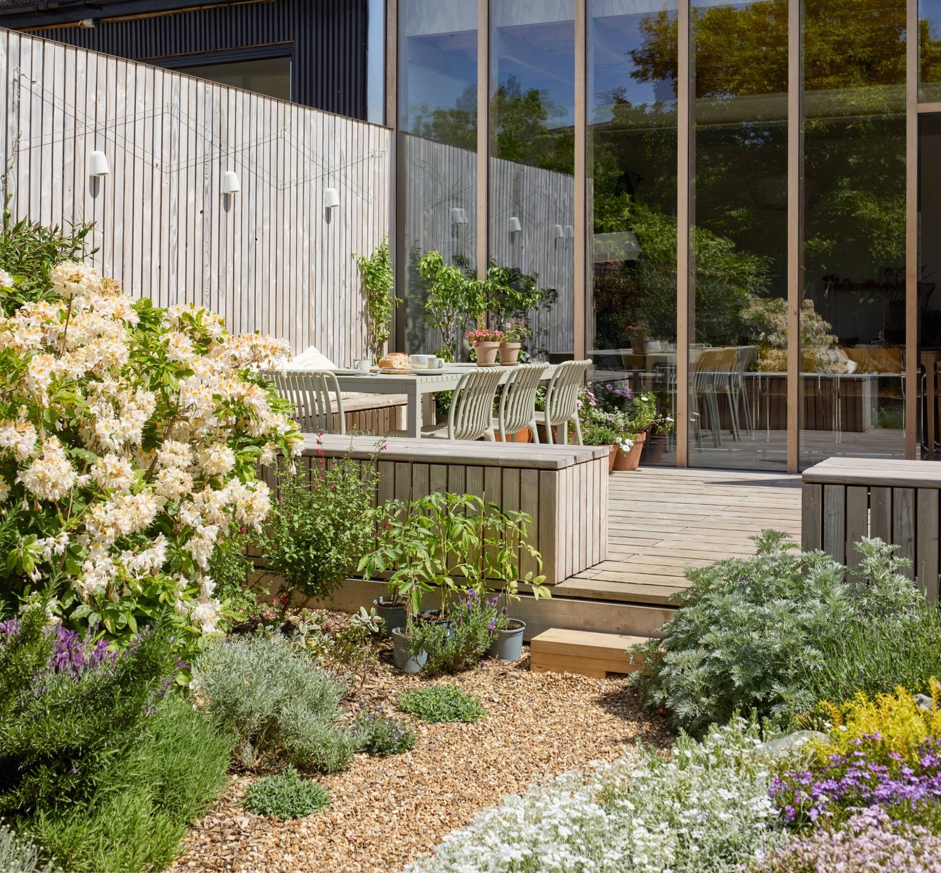 Timber deck patio terrace set with outdoor seating beside gravel garden borders, Love Locations E17.