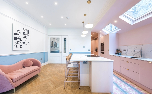 Spacious open-plan kitchen and family room looking towards elegant white double doors and oak herringbone flooring, Love Locations.