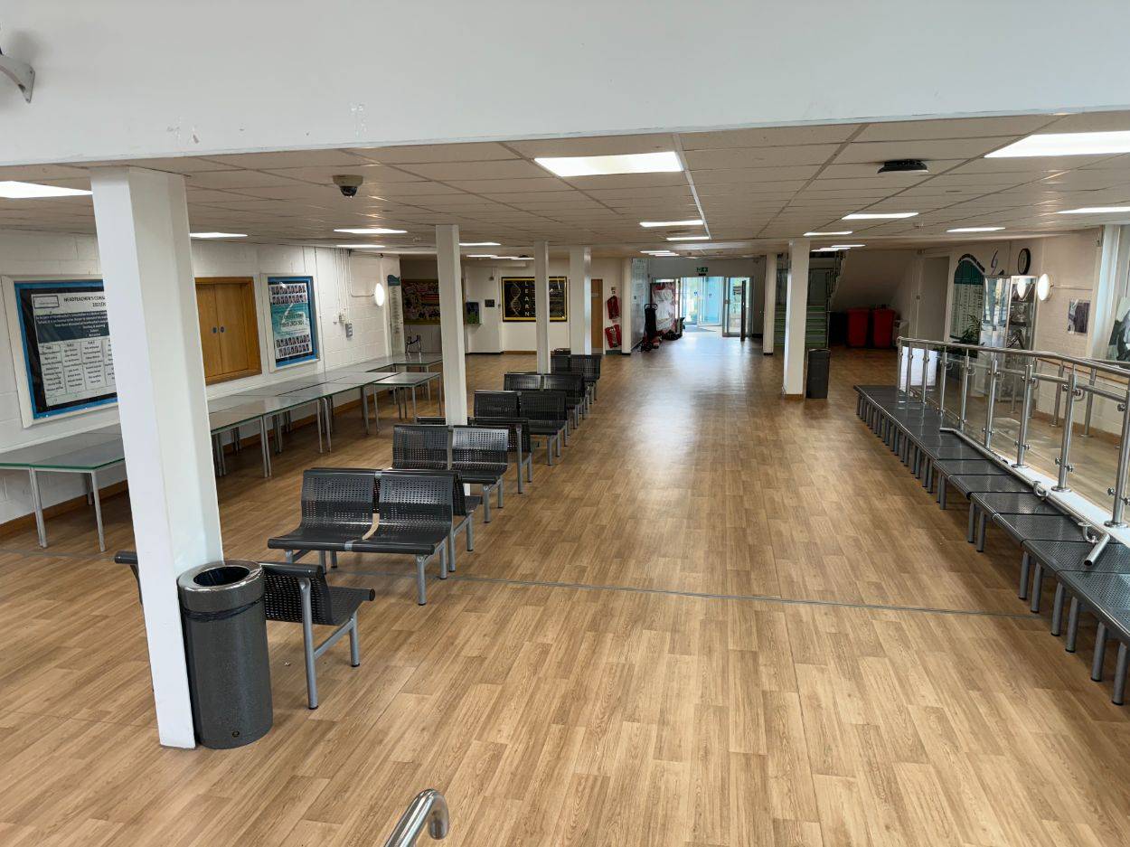 School hallway and dining corridor filming space featuring vinyl wood-effect flooring and modern seating via Love Locations.