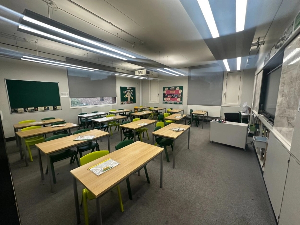 Modern secondary school classroom shoot location with wooden desks and green chairs in East Dulwich, SE22, available via Love Locations.