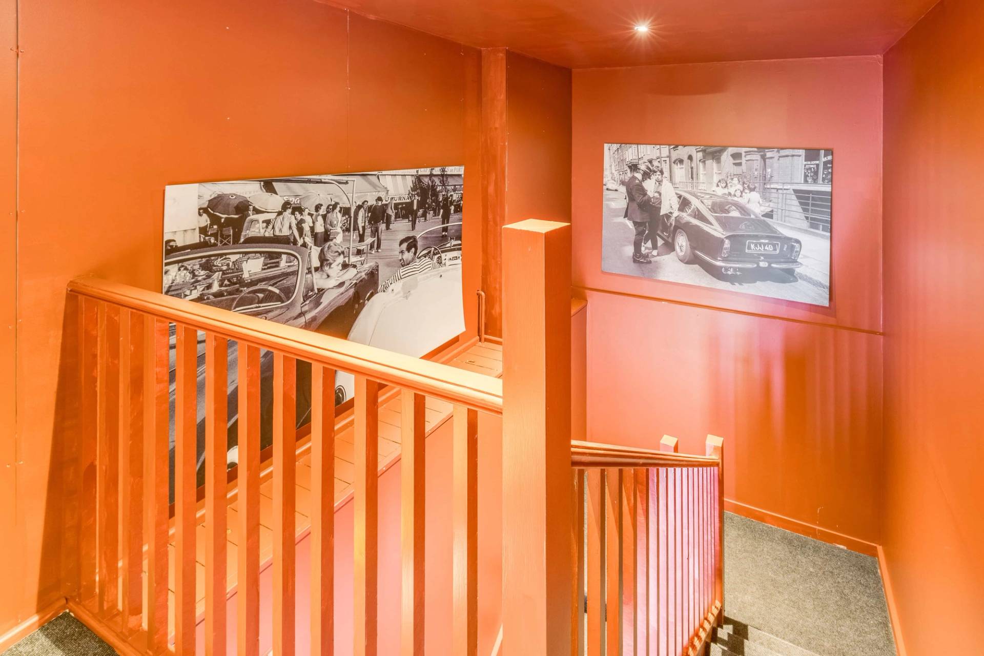Stunning terracotta-toned staircase landing with framed monochrome artwork, ideal for fashion lifestyle shoots, Love Locations.