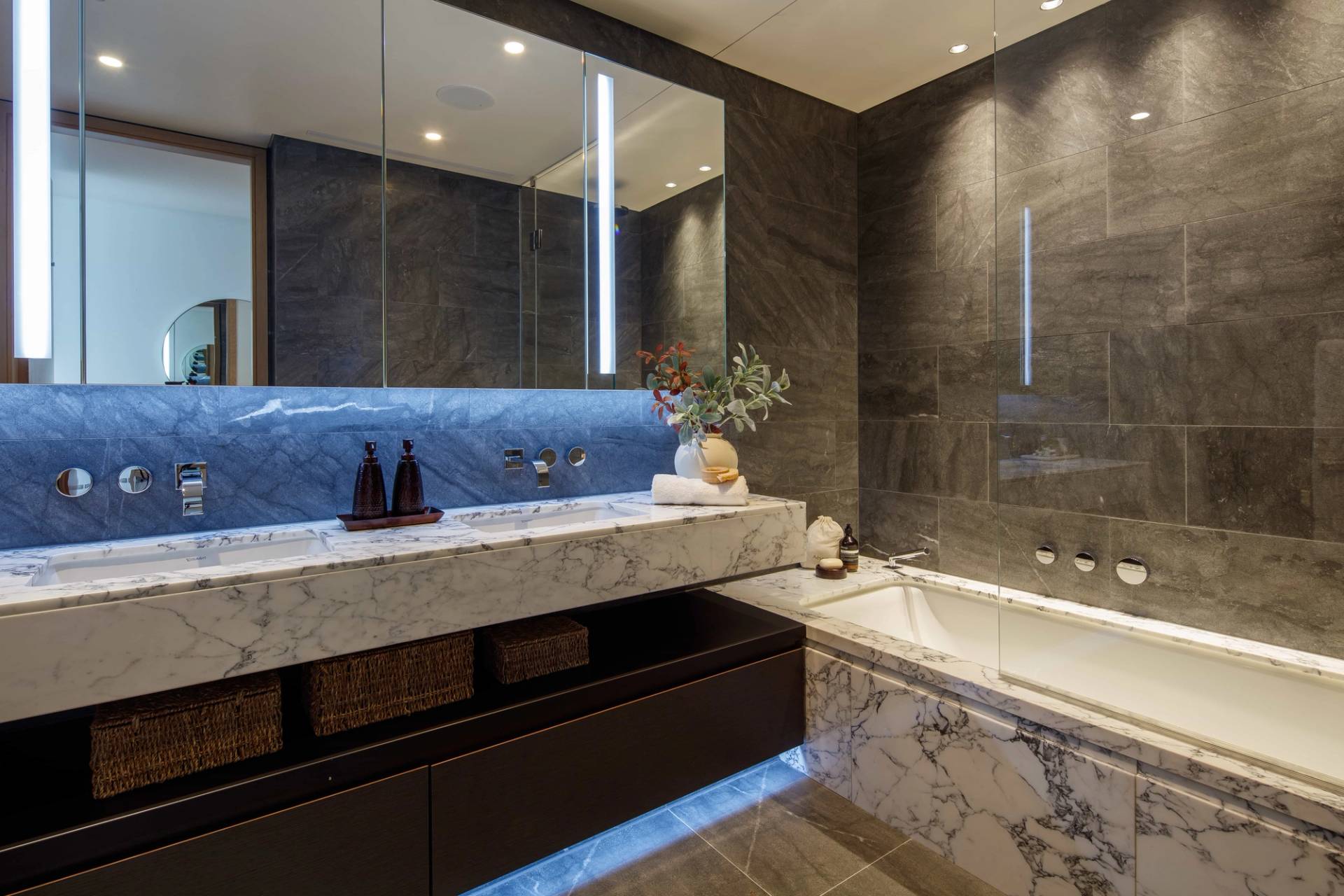 Modern dark marble bathroom with mirror vanity and integrated bathtub in an EC2A location penthouse near Liverpool Street Station, Love Locations.