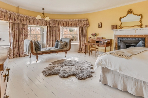 Spacious yellow master bedroom with bay window, chaise lounge, and writing desk in Fife, Love Locations KY15.