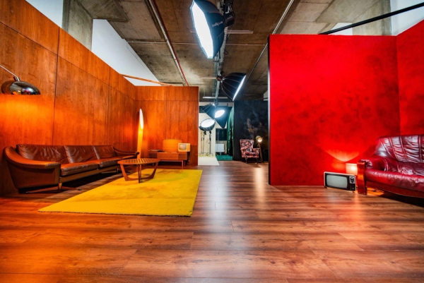Spacious studio floor featuring 1970s mid-century wood panelled wall set, yellow rug, and red feature wall, Love Locations N15.