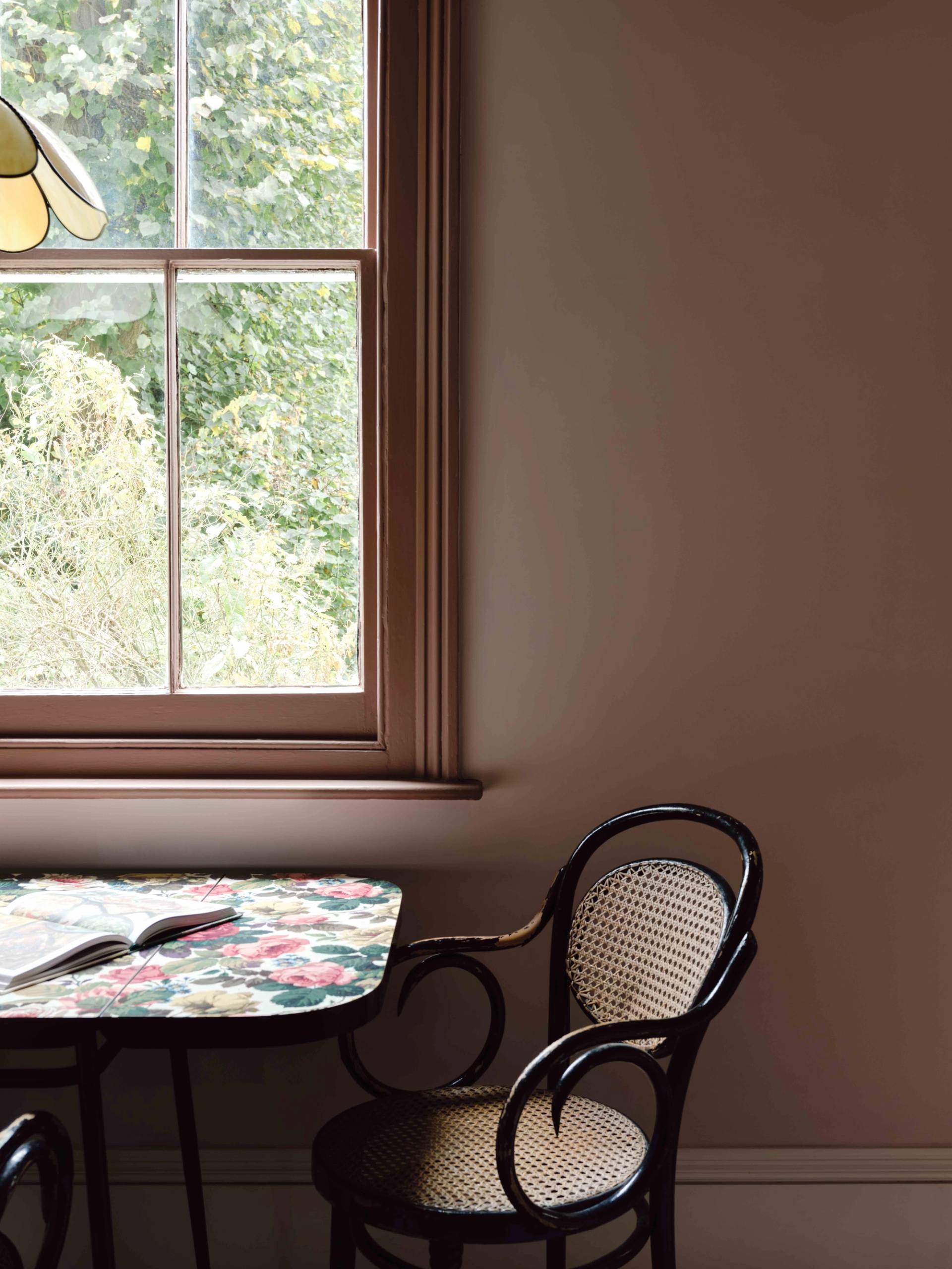 Sash window nook in a pink kitchen styled with a floral table setting and black bistro chair, Love Locations CR0.