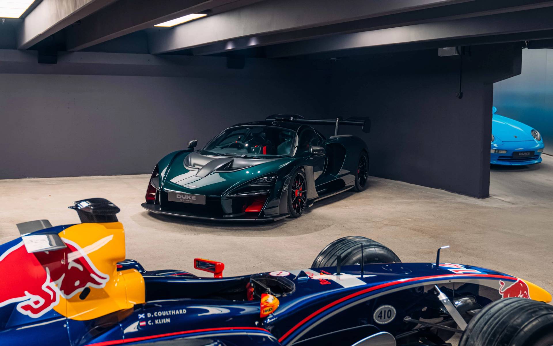 Dark moody subterranean supercar vault featuring a dark green hypercar and Formula 1 race car through Love Locations.