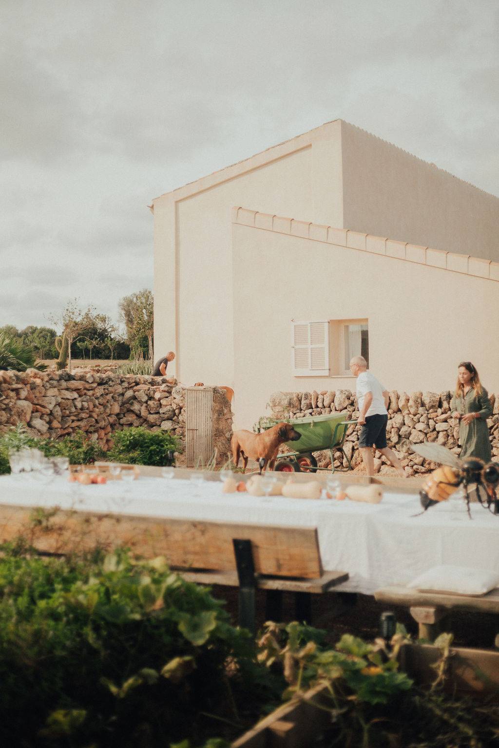 Outdoor event dining table layout set up outside a traditional white villa outbuilding, Love Locations 07630.