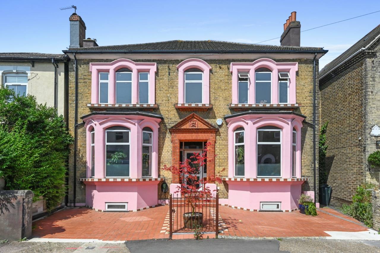 Vibrant pink-fronted double bay Victorian house hero cover image in Newham, E7 featuring terracotta tiled front garden steps, wrought-iron gates, raw plaster interiors, and an expansive garden, the ultimate high-visibility backdrop for feature film productions, TV commercials, fashion editorials, and brand campaigns via Love Locations.