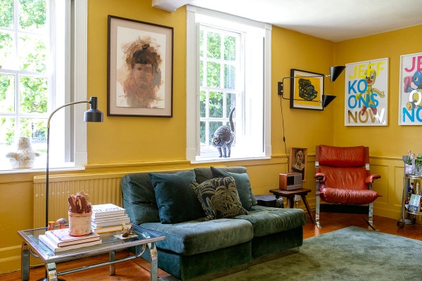 Yellow reception lounge featuring a dark green velvet sofa, sash windows, and framed artwork, Love Locations RG42.
