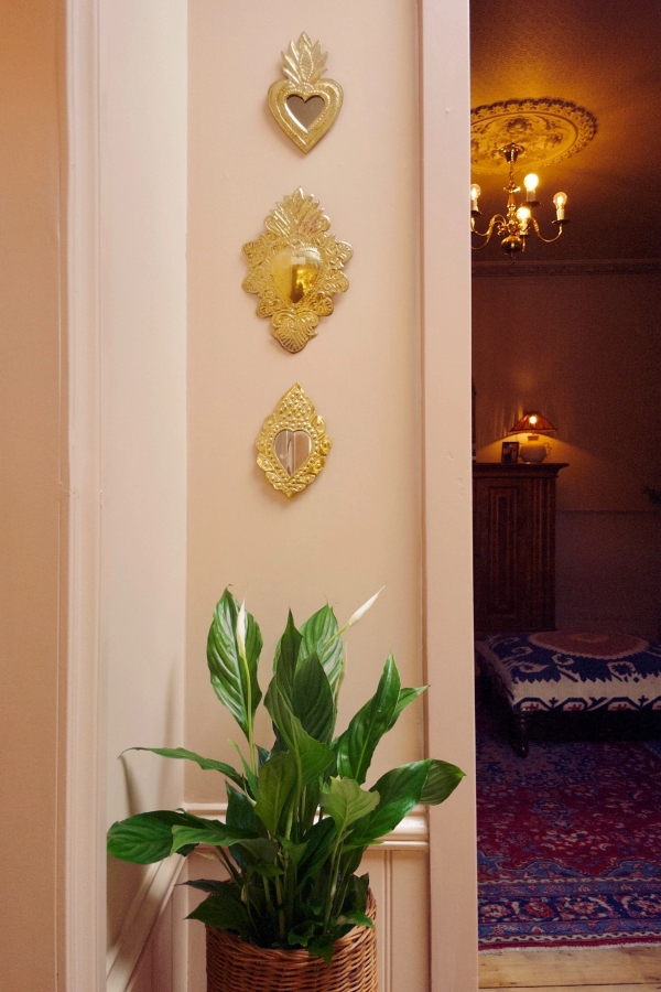 Stylized hallway wall featuring gold decorative wall sconces and a large green potted houseplant, perfect for luxury interior backdrops, Love Locations TW7.