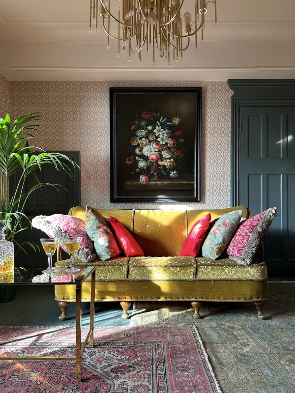 Yellow velvet sofa set against dark green walls and framed floral art in an Edwardian home, Love Locations N13.
